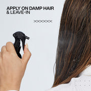 Redken Leave-In Spray being misted onto damp hair.